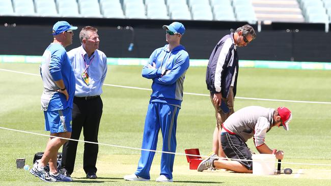 Australian captain Steve Smith stands, Darren Lehmann and former chief of selectors Rod Marsh deep in conversation.