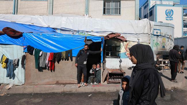 A woman and a child walk past an UNRWA school housing displaced Palestinians in the Rafah refugee camp in the southern Gaza Strip. Picture: AFP