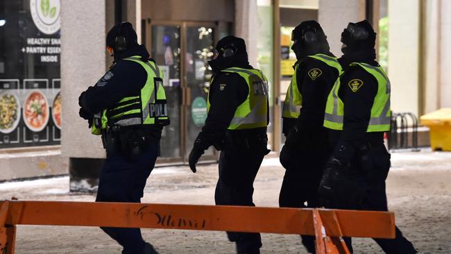 Police march on Wellington Street as truckers continue their rally over the weekend near Parliament Hill. Picture: Getty Images/AFP.