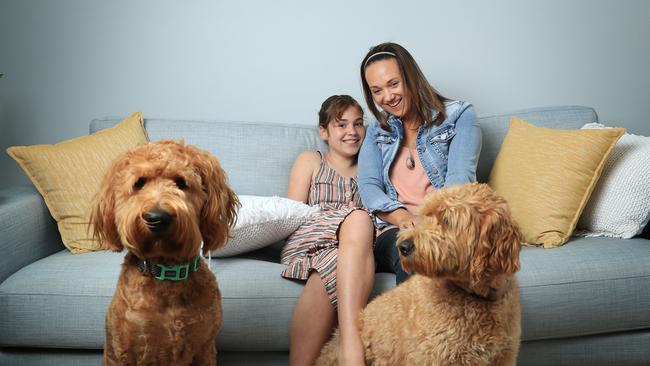 Sandy Golder with her daughter Imogen, who has autism, and dogs Coco and Baxter at home at St Clair in western Sydney. Picture: John Feder