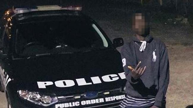 A youth posing in front of a police car was posted on social media.