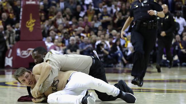 A man is tackled by police and security after running onto the court during the second half in Game 4 of the 2016 NBA Finals.