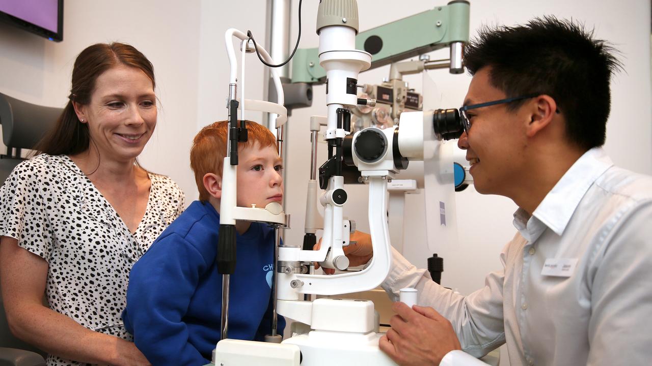 Kevin Paisley optometrist Jason Loh with young patient Oli Pryke and mum Lauren Middleton. Picture: Alison Wynd