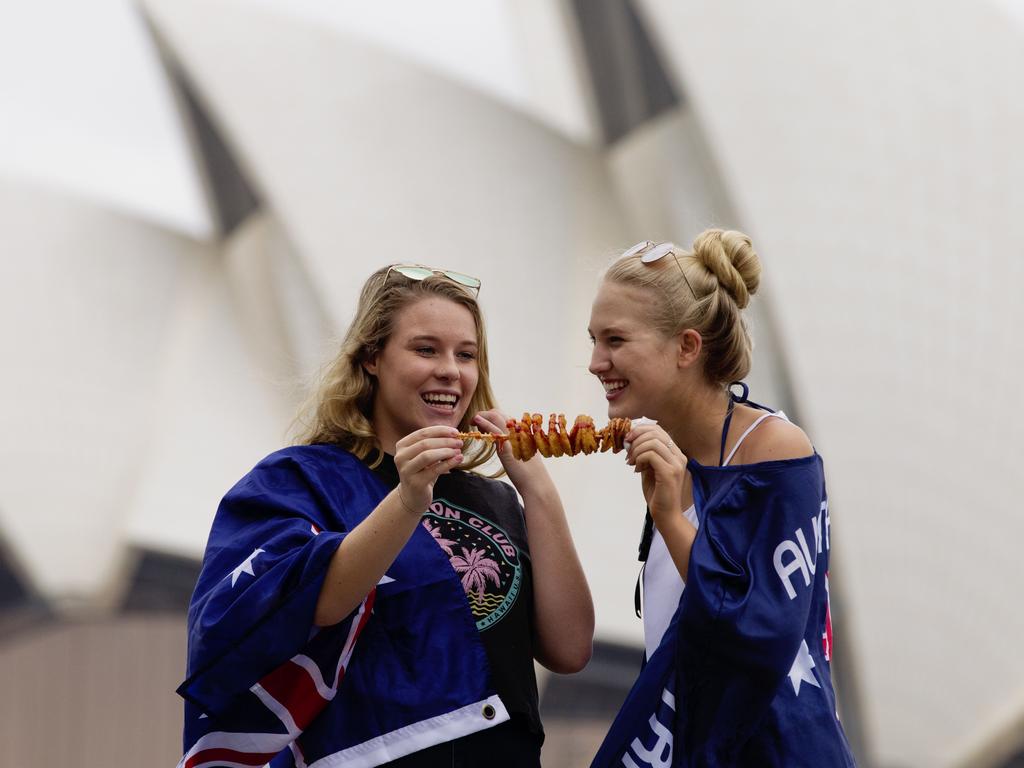 (L-R) Rachel Vielhauer and Georgia Thorpe enjoy chips on a stick during Australia Day at Circular Quay in Sydney. Picture: Jenny Evans