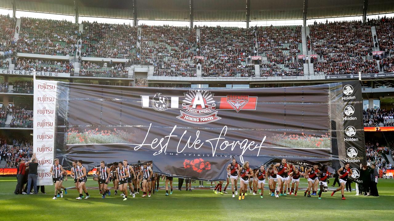 Collingwood and Essendon run through the banner on ANZAC DAY 2018. Photo: Adam Trafford/AFL Media/Getty Images.