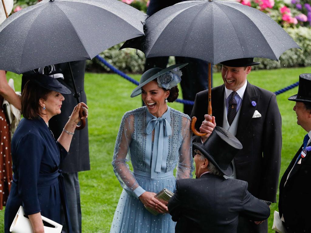 William was happy to shield his wife from the rain as they chatted to guests. Picture: Adrian Dennis/AFP