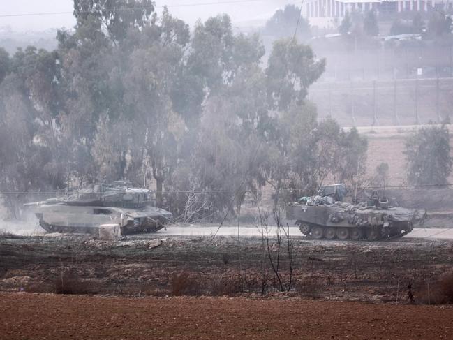 A picture taken from southern Israel near the border with the Gaza Strip shows Israeli armoured vehicles returning from the Palestinian territory. Picture: AFP