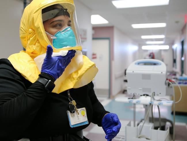 A therapist decontaminates her PPE. Picture: AFP