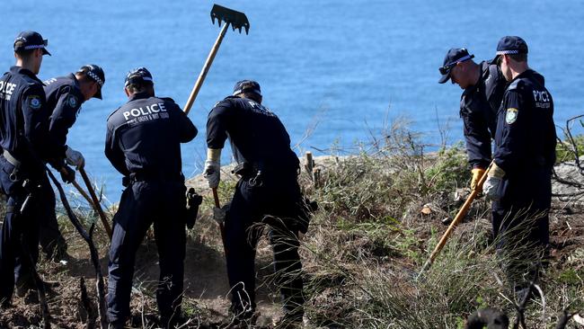 NSW Police using rakes to comb through the undergrowth on North Head. Picture: Toby Zerna