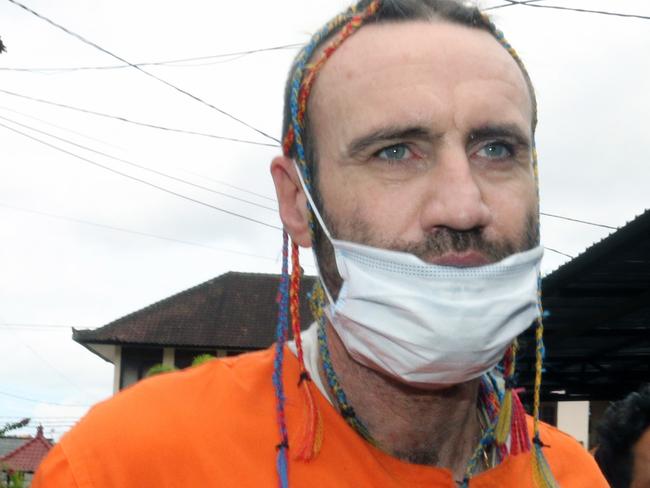 Australian Travis James McLeod, 43, escorted by police at Denpasar Police Station for his case on possessing 0.8 grams of methampethamine and kratom leaves. Picture. Lukman S. Bintoro