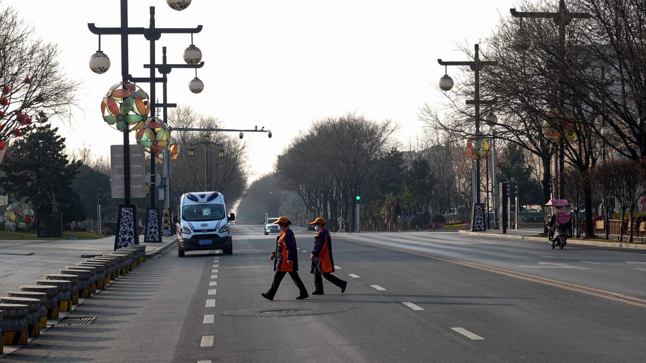 People cross a road in Xi'an in China's northern Shaanxi province on December 31, 2021, amid a Covid-19 coronavirus lockdown. Picture: AFP