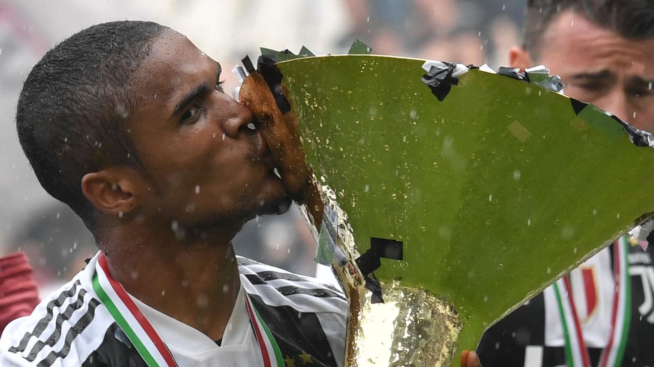 Juventus’ Douglas Costa kisses the trophy following the Italian Serie A match against Verona.