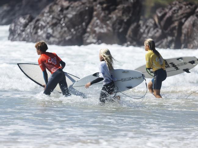 Surfers enter the waves at the Reflections Cadet Cup at Bonny Hills.