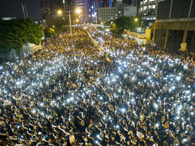 Protesters and student demonstrators hold up their cellphones in a display of solidarity outside the headquarters of Legislative Council in Hong Kong. Pic: AFP.