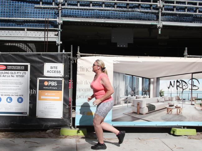 A jogger runs by the scene at the Shoreline tower construction site at 61 Old Burleigh Rd. The site is locked up as builder PBS is rumoured to have gone into liquidation. Picture Glenn Hampson