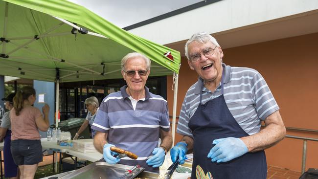 Owen Ford (left) and Geoffrey Bullock cook up the democracy sausage barbecue in a fundraiser for the Harristown State High School chaplain in the Queensland state election, Saturday, October 31, 2020. Picture: Kevin Farmer