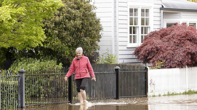 Julie Lunson walks through flood waters from her home in Latrobe. Picture: Grant Viney