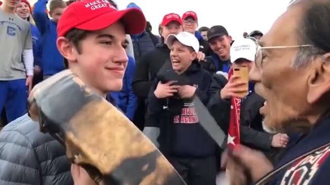 Nick Sandmann, left, faces Native American elder Nathan Phillips.