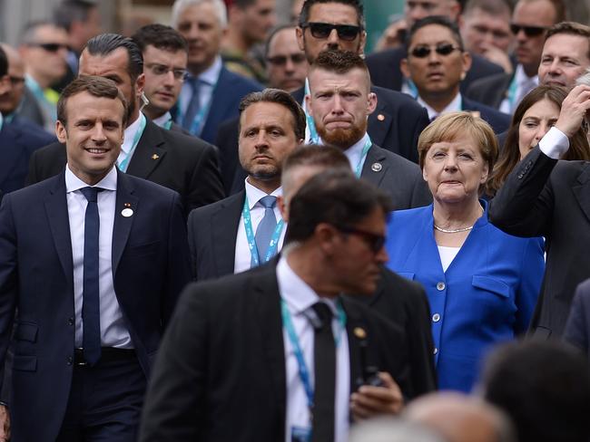 French President Emmanuel Macron (L) German Chancellor Angela Merkel and Italian Prime Minister Paolo Gentiloni arrive during a G7 summit. Picture: AFP.