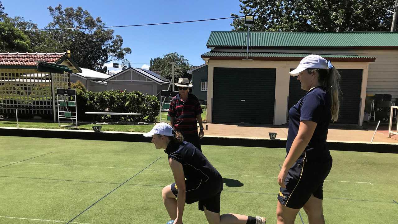 ROLL UP: Fairholme College students Sophie Mossman and Charlie Keegan practice their lawn bowls skills under the watchful eye of a Toowoomba Bowls Club member. Picture: Contributed