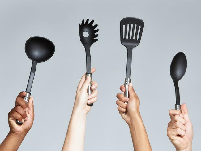 Group of keen cooks holding up a variety of kitchen implements, including ladle, spaghetti lifter, spatula, serving spoon and potato masher.