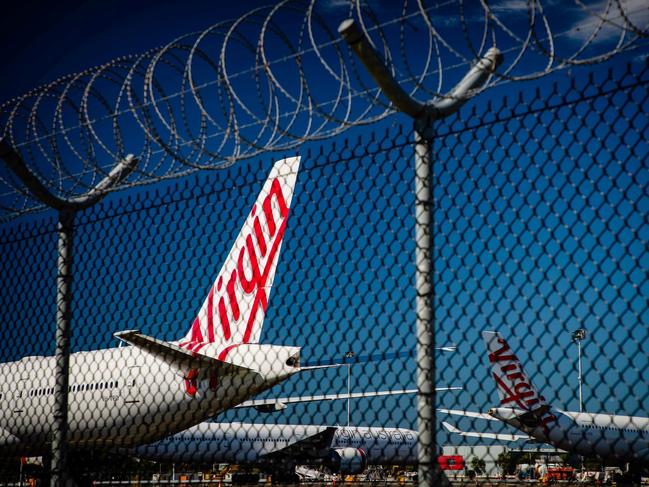 Virgin Australia aircraft are seen parked on the tarmac at Brisbane International airport on April 21, 2020. - Cash-strapped Virgin Australia collapsed on April 21, making it the largest carrier yet to buckle under the strain of the coronavirus pandemic, which has ravaged the global airline industry. (Photo by Patrick HAMILTON / AFP)