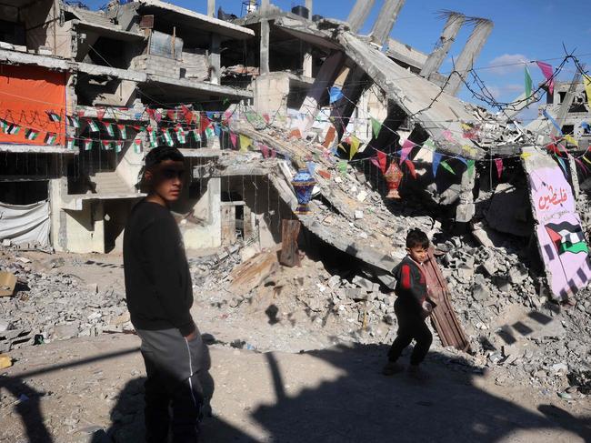 Palestinian youths walk in war-devastated neighbourhood, decorated ahead of the Muslim holy fasting month of Ramadan, in Khan Yunis in the southern Gaza Strip. Picture: AFP