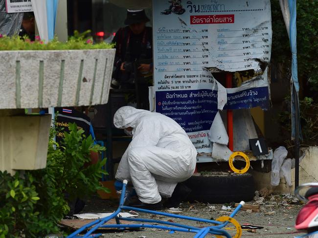 An investigation official collects evidence from the crime scene after a small bomb exploded in Hua Hin. Picture: AFP