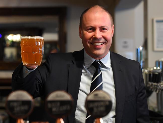 Josh Frydenberg holds up a beer at the Glenferrie Pub in Melbourne. Picture: AAP