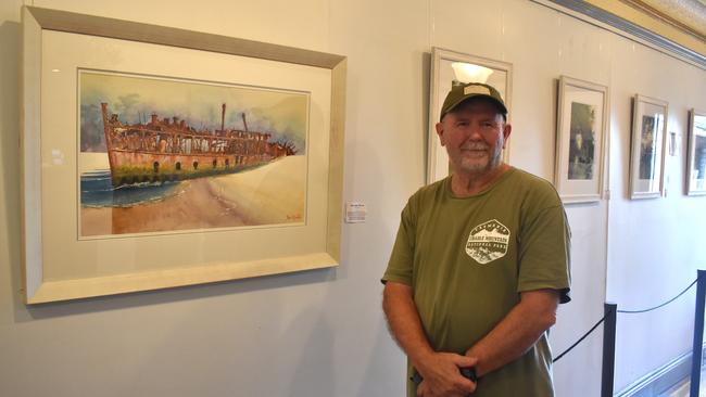 Australian watercolour artist Bruce Griffiths stands next to his favourite detailed piece (SS Maheno) in his 18th solo exhibition at the Toowoomba Reparatory Theatre.