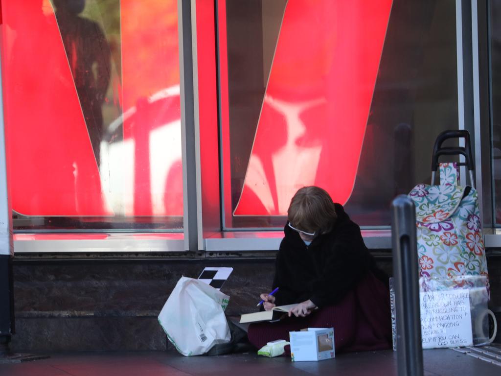 Gene Phillips seeks refuge outside a Westpac branch on Park St in Town Hall. Picture: John Grainger