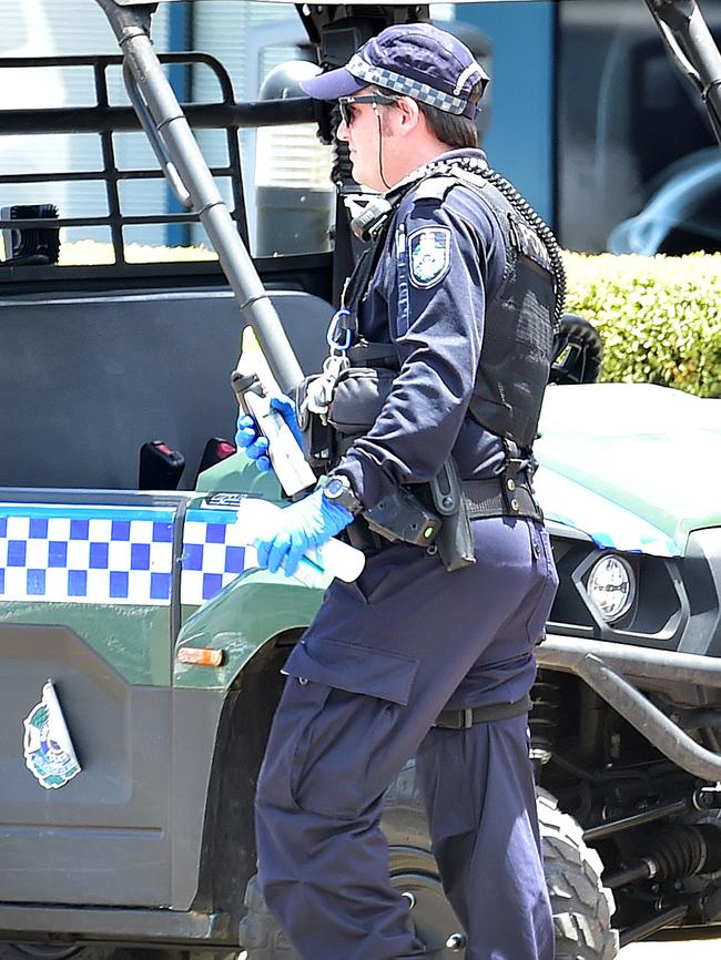 Police officers holding what appears to be deoderant spray cans confiscated at the bus stop at 48 Thuringowa Drive, Kirwan. Picture: Shae Beplate.