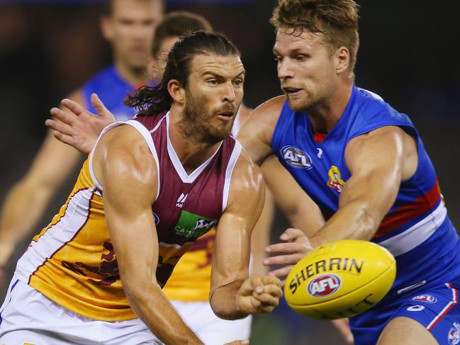 MELBOURNE, AUSTRALIA - MARCH 02:  Rohan Bewick of the Lions handballs  away from Jake Stringer of the Bulldogs during the 2017 JLT Community Series AFL match between the Western Bulldogs and the Brisbane Lions at Etihad Stadium on March 2, 2017 in Melbourne, Australia.  (Photo by Michael Dodge/Getty Images)