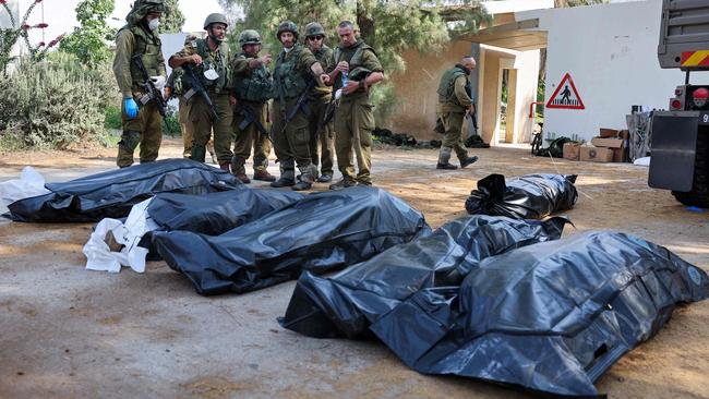 Israeli soldiers with the bodies of their slain colleagues in the Kfar Aza kibbutz. Picture: AFP