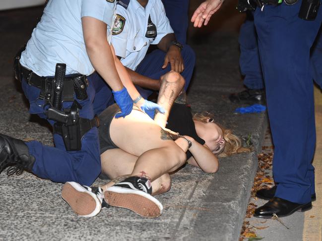 Amati lies on the footpath before being taken to hospital and then questioned about the attack. Picture: Gordon McComiskie 