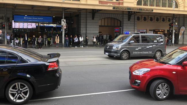 A Critical Incident Response Team van rushing down tram lines in the middle of Flinders St during a pursuit this morning.