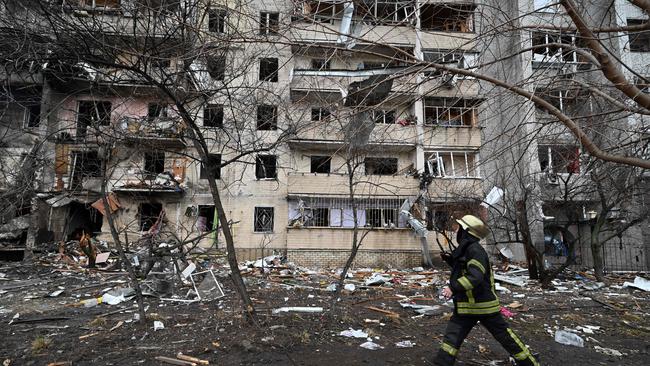 Firefighters work at a damaged residential building at Koshytsa Street, a suburb of the Ukrainian capital Kyiv, where a military shell allegedly hit, on February 25, 2022. (Photo by GENYA SAVILOV / AFP)