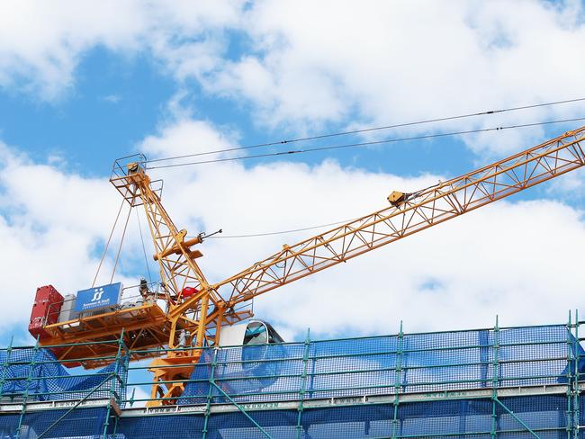 A crane worker stands on the boom above Citro apartments on Victoria Street, West End. Work has ceased on the construction site while the developer looks for a builder. (AAP Image/no byline)