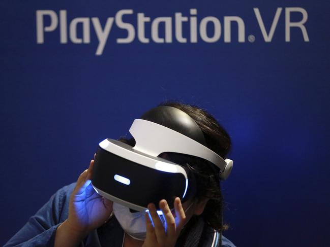 FILE - In this Sept. 15, 2016, file photo, a visitor tries out a Sony's PlayStation VR headgear device at the Tokyo Game Show in Makuhari, near Tokyo. Unlike the Oculus Rift and HTC Vive, PlayStation VR works in unison with a PlayStation 4 console instead of a high-end PC. It's also cheaper, more comfortable and will be the most convenient option for VR seekers when it's released Oct. 13. (AP Photo/Eugene Hoshiko, File)