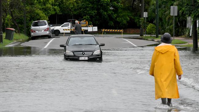 Flash flooding in Townsville after heavy overnight rain. Tow truck driver inspects car stuck in flooded section of Bayswater Tce. Picture: Evan Morgan