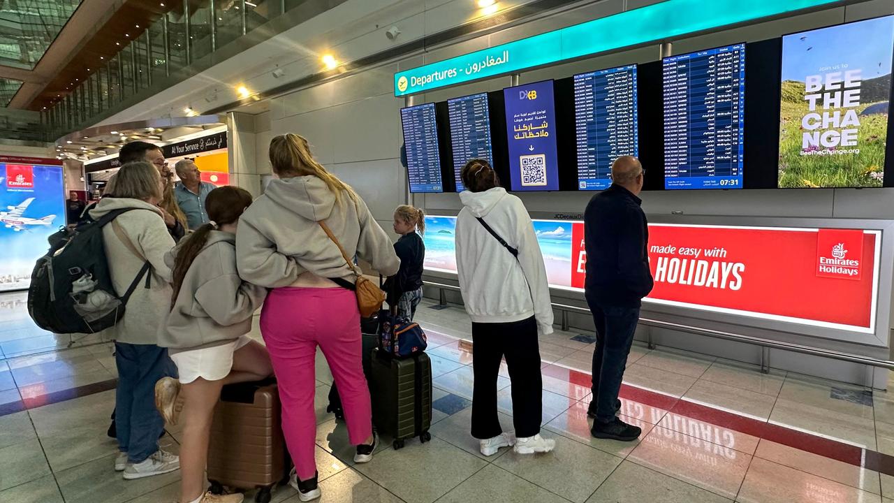 Passengers check flight information on screens at the Dubai International Airport on April 17. Picture: AFP)