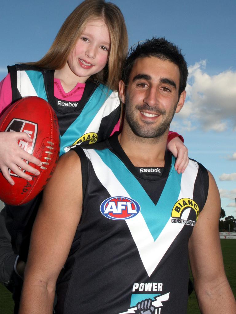 A seven-year-old Lucy Burford with Port Adelaide captain Dom Cassisi in 2009.