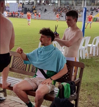 Tom Liberatore gets a haircut on the bench.