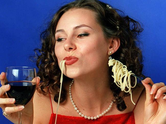 Apr 1999 generic  etiquette / table manners situation woman / model eating plate of spaghetti drinking glass red wine headshot food pasta