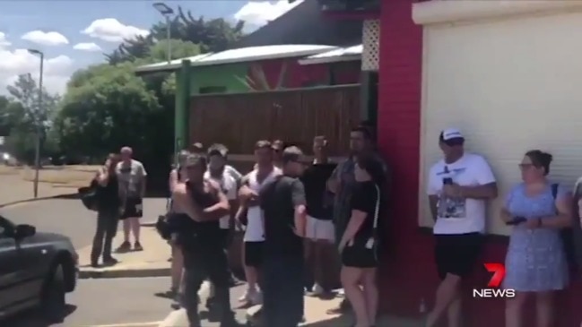 People line up in 45+ degree heat for free beer