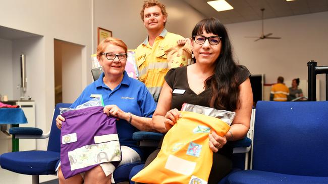 President of Soroptimist International Townsville Breakwater Janet Askern, Ergon Energy Linesman Jarrad Jeffrey and President of Joyful Foundation Grace Vigar with prison made library bags for kids. Picture: Alix Sweeney