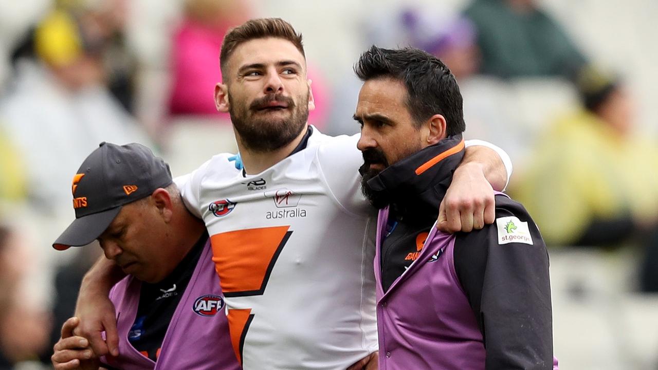 Stephen Coniglio is helped off the MCG on Sunday.