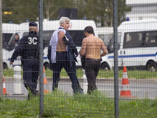 Shaken ... Air France director of human resources Xavier Broseta, right, and Air France assistant director long-haul flight, Pierre Plissonnier, centre, are protected by a police officer. Picture: AP Photo/Jacques Brinon