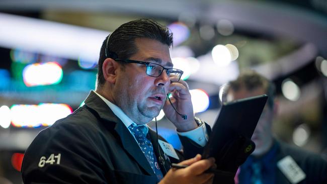 Traders work after the opening bell at the New York Stock Exchange (NYSE) on July 16, 2019, in New York City. - Wall Street stocks edged down from records early Tuesday following mixed banking earnings and worrisome manufacturing data contrasted with strong US retail sales. Shares of JPMorgan Chase, the largest US bank by assets, were slightly negative despite reporting record quarterly earnings as investors focused on the bank's lowered forecast for net interest income in anticipation of Federal Reserve moves to cut interest rates. (Photo by Johannes EISELE / AFP)