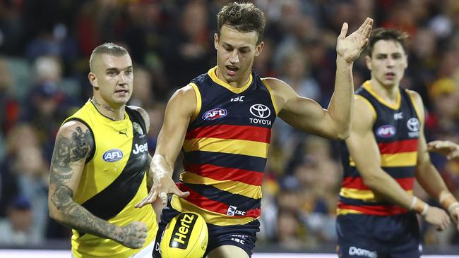 Tom Doedee gets his kick away with Dustin Martin in the background. Picture: Sarah Reed